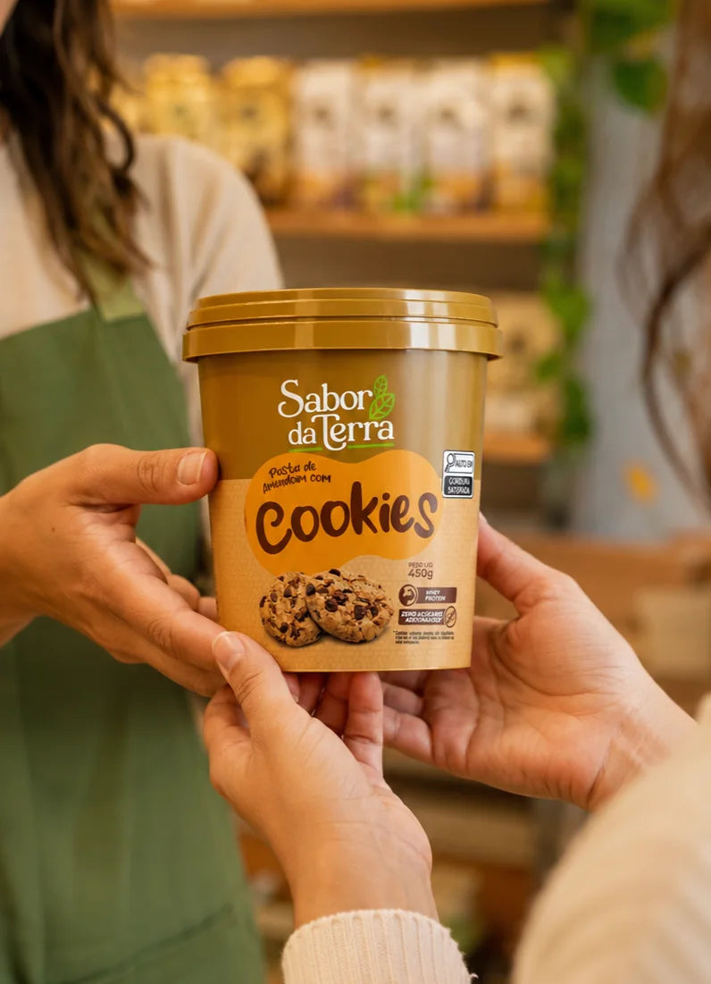 Cliente recebendo um pote Sabor da Terra na loja